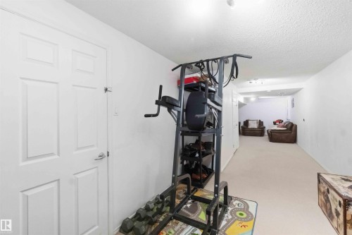 Recessed lighting illuminates this versatile lower-level space featuring light-toned carpeting and neutral white walls - 18808 72A Avenue, Edmonton, AB 