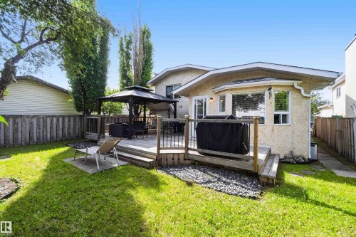 Spacious backyard featuring a multi-level wooden deck with black railings - 18808 72A Avenue, Edmonton, AB 