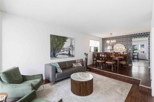 Living area featuring light wood-finish flooring and a dining area with dark wood-finish flooring - 18808 72A Avenue, Edmonton, AB 