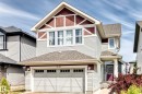 Two-story residence featuring light gray siding with maroon accent panels, a shingled roof, an attached two-car garage, multiple upper-level windows with white trim, and a prominent front entry with a purple door - 8730 180A Avenue, Edmonton, AB 
