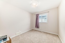 Carpeted interior room featuring a window with white trim, a flush-mount ceiling light fixture, and pale wall finishes - 