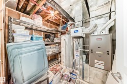 Utility area with exposed wood framing, metal shelving, water heater, furnace, and extensive ductwork - 