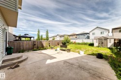 Expansive concrete patio with curved steps leading to a manicured lawn - 