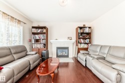 Living area featuring wood-finish flooring and a tiled fireplace with a mantel - 