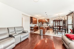 Open-concept living space with dark wood-finish flooring extending into the kitchen - 