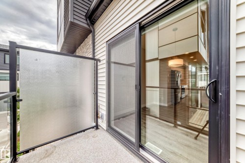 Private balcony with textured glass railing and sliding patio door access - 26 1729 Keene Crescent, Edmonton, AB 