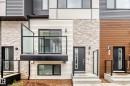 Modern multi-level exterior featuring a glass-paneled balcony, horizontal siding, stone veneer accents, and contemporary entry doors with frosted glass inserts - 26 1729 Keene Crescent, Edmonton, AB 