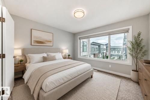 Bedroom featuring a large window, neutral carpeting, light gray walls, a flush-mount ceiling light, and white baseboards - 26 1729 Keene Crescent, Edmonton, AB 