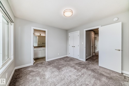 Carpeted room featuring a double-door closet, a window with roller shades, and light gray wall paint - 26 1729 Keene Crescent, Edmonton, AB 