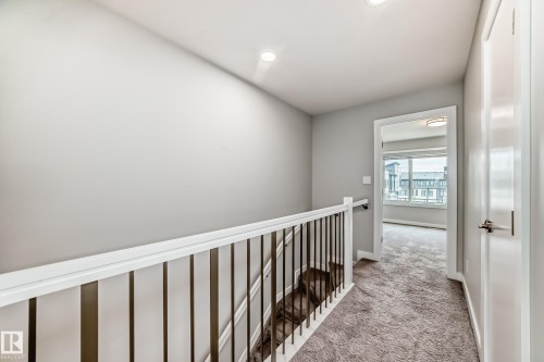 Upper-level hallway with contemporary gray walls, recessed lighting, and plush carpet flooring - 26 1729 Keene Crescent, Edmonton, AB 