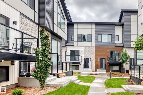 Contemporary multi-level townhome exteriors featuring horizontal and vertical siding, stone accents, and wood-finish paneling - 26 1729 Keene Crescent, Edmonton, AB 