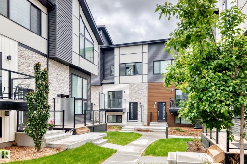 Contemporary townhome exterior featuring multiple textures including horizontal siding, vertical panels, and stacked stone accents - 26 1729 Keene Crescent, Edmonton, AB 