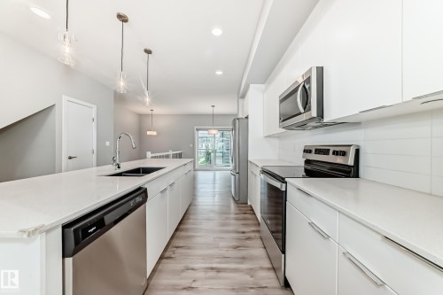 Modern kitchen featuring white cabinetry and light countertops - 26 1729 Keene Crescent, Edmonton, AB 