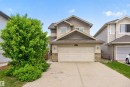 Two-story residence featuring light-colored siding, a prominent attached two-car garage, and stone accents - 4612 Westcliff Point(E), Edmonton, AB 