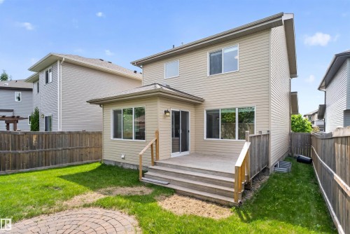 Rear exterior featuring a multi-level wood deck with steps, sliding glass patio door, and multiple windows - 4612 Westcliff Point(E), Edmonton, AB 