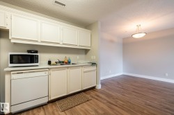 Functional kitchen area featuring white cabinetry, a single basin sink, and white countertop - 