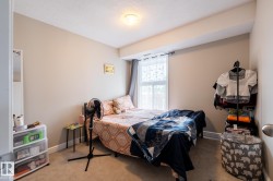 Bedroom featuring neutral wall paint, carpet flooring, a window with curtains, and a ceiling-mounted light fixture - 