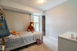 Carpeted room featuring a window with white drapes, light-toned walls, and a built-in overhead light fixture - 