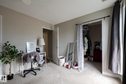 Carpeted interior room with neutral-toned walls, white trim, and a ceiling fan - 