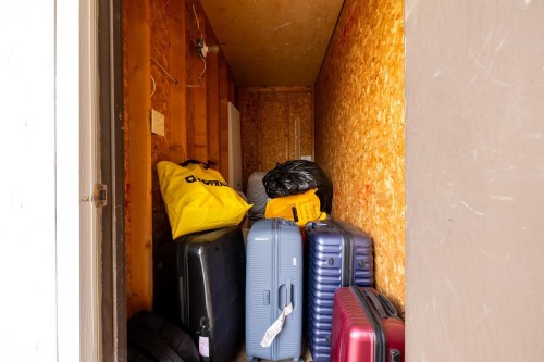 Storage space featuring exposed OSB walls and ceiling, visible electrical wiring, and a single light fixture - 8 2703 79 Street, Edmonton, AB 