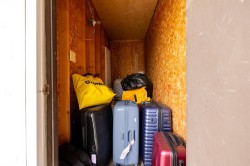 Storage space featuring exposed OSB walls and ceiling, visible electrical wiring, and a single light fixture - 