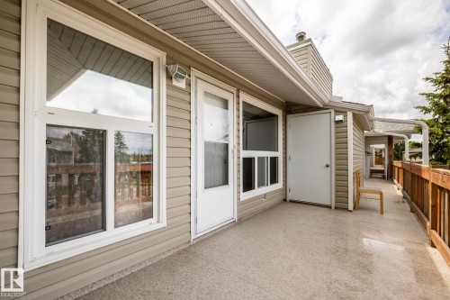 Exterior balcony featuring a concrete surface and a wooden railing - 8 2703 79 Street, Edmonton, AB 