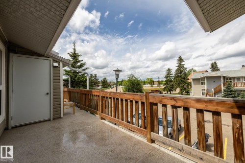 Spacious outdoor balcony with a wood railing and concrete flooring - 8 2703 79 Street, Edmonton, AB 