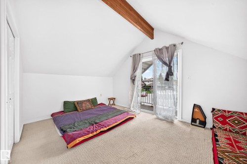 Vaulted ceiling room featuring a wood beam and light-colored carpeting - 8224 186 Street Nw, Edmonton, AB 