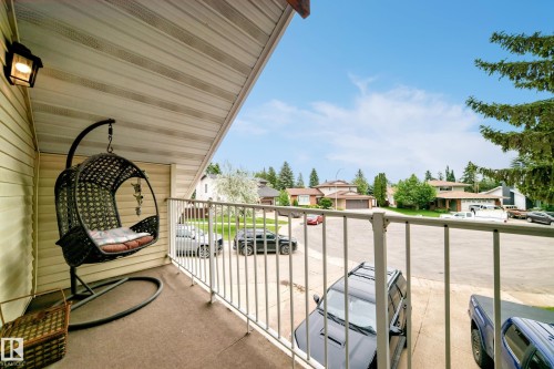 Covered balcony with light-toned siding, white overhead soffit, and white metal railings - 8224 186 Street Nw, Edmonton, AB 