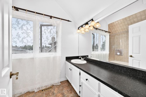 Bathroom featuring a vanity with a black speckled countertop, an integrated sink, and white cabinetry - 8224 186 Street Nw, Edmonton, AB 