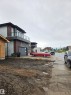 Contemporary exterior featuring horizontal siding, stone cladding, and a second-story balcony with glass railings - 113 29A Street, Edmonton, AB 