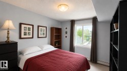 Bedroom featuring a window with exterior visibility, light gray wall paint, and ceiling-mounted lighting - 