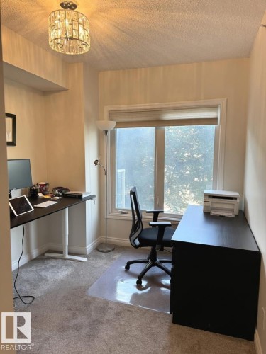 Bright room featuring a large window, neutral wall paint, and soft grey carpeting - 305 11111 82 Avenue, Edmonton, AB 
