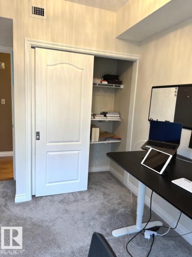 White sliding door closet with interior shelving and light gray carpeting - 305 11111 82 Avenue, Edmonton, AB 
