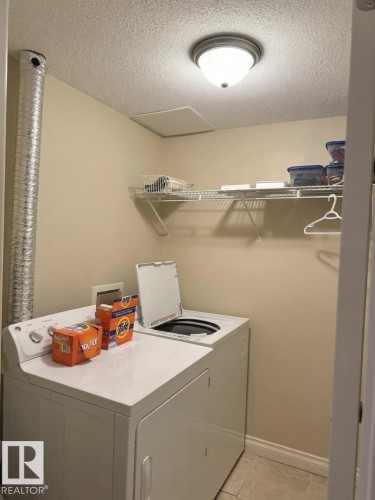 Dedicated laundry area featuring tile flooring and neutral wall tones - 305 11111 82 Avenue, Edmonton, AB 