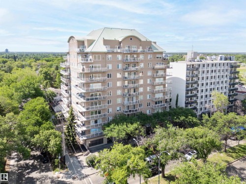Multi-story condominium building featuring a light-colored exterior and a light green roof - 305 11111 82 Avenue, Edmonton, AB 