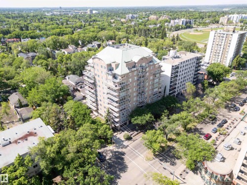 High-rise building featuring a light-colored facade, numerous balconies, and a distinctive green roof - 305 11111 82 Avenue, Edmonton, AB 