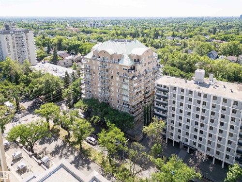 Multi-story building featuring numerous balconies, a distinct green roof, and a beige exterior facade - 305 11111 82 Avenue, Edmonton, AB 