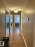 Hallway featuring wood-finish flooring, a semi-flush mount ceiling light fixture, and neutral wall tones - 305 11111 82 Avenue, Edmonton, AB 