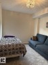 Recessed lighting complements a decorative flush-mount ceiling fixture, illuminating soft gray carpeting and light-toned walls - 305 11111 82 Avenue, Edmonton, AB 