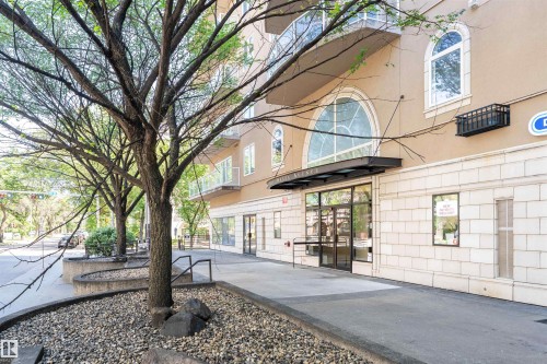 Contemporary building exterior featuring a stone-clad first level and smooth stucco upper floors - 305 11111 82 Avenue, Edmonton, AB 