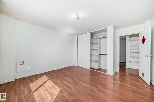 Expansive room featuring wood-finish flooring, white walls, and a recessed ceiling light fixture - 401 11007 83 Avenue, Edmonton, AB 