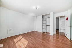 Expansive room featuring wood-finish flooring, white walls, and a recessed ceiling light fixture - 