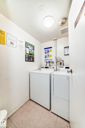 Dedicated laundry area featuring a white top-load washing machine and front-load dryer - 401 11007 83 Avenue, Edmonton, AB 