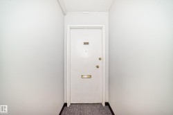 Entryway featuring a white door with brass hardware, a brass mail slot, and a peephole - 
