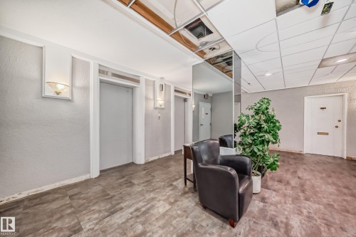 Hallway featuring wood-look flooring and textured wall finishes - 401 11007 83 Avenue, Edmonton, AB 