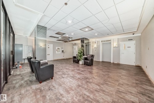 Spacious common area featuring wood-finish flooring, recessed lighting, and a mail center - 401 11007 83 Avenue, Edmonton, AB 