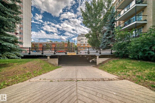 Concrete ramp entrance to an underground parking facility, featuring sloped, grooved paving - 401 11007 83 Avenue, Edmonton, AB 