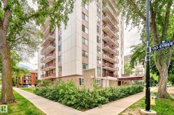 Multi-story residential building featuring balconies with red railings and a ground-floor awning - 