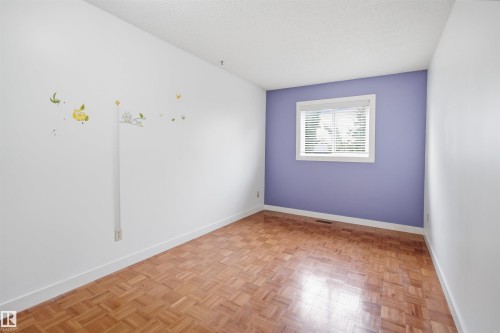 Room featuring parquet wood flooring, white baseboards, and a window with white blinds - 3220 42A Avenue, Edmonton, AB 